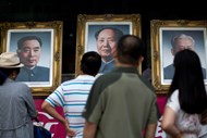 Os retratos de três antigos líderes chineses - Zhou Enlai à esquerda, Mao Zedong ao centro e Liu Shaoqi - numa loja em Pequim.