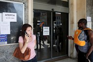 Pessoas à porta de uma estação de comboio, em Atenas, que está encerrada devido a greve.