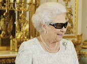 Rainha Isabel II com óculos 3D, com cristais da Swarovski, no Palácio de Buckingham para ver a sua mensagem de Natal em 2012.