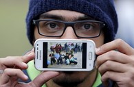 Basas, de Damasco, Síria, mostra uma fotografia da escola onde trabalhou como voluntário. 