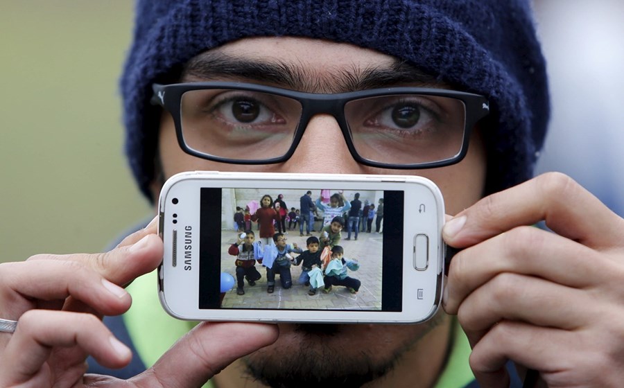 Basas, de Damasco, Síria, mostra uma fotografia da escola onde trabalhou como voluntário. 