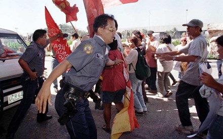 Manila, Fevereiro de 1997: polícias tentam bloquear dezenas de manifestantes durante um protesto à porta do edifício onde decorria um  encontro de líderes