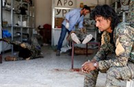 Um soldado das Syrian Democratic Forces, que foi atingido por um tiro de um sniper do Estado Islâmico, é assistido por um médico num hospital em Raqqa, na Síria.