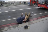 Uma mulher assiste uma pessoa ferida durente um incidente terrorista na ponte de Westminster, em Londres.