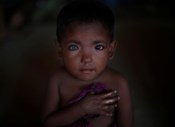 Hosne Ara, uma criança Rohingya de quatro anos, ouve uma canção no centro para crianças do campo de refugiados no Bangladesh.