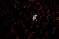 A luz de um telemóvel ilumina o rosto de uma mulhar saudita, durante a actuação da cantora Majid Al Muhandis em Manama, no Bahrein.