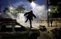 Um manifestante ataca um veículo em protesto contra a proposta do presidente Michel Temer de reformar o sistema de segurança social do Brasil.