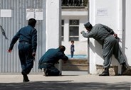 Polícia afegão tenta salvar uma criança de quatro anos durante um conflito entre as forças do país e insurgentes numa mesquita em Cabul. 