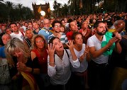 Catalães assistem a uma sessão no Parlamento da Catalunha através de um écran-gigante, numa rua em Barcelona.