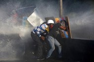 Apoiantes da oposição a Nicolas Maduro enfrentam as forças de segurança durante um motim em Caracas, na Venezuela.