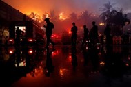 Polícias de guarda no hotel Kandawgyi Palace durante um incêndio em Yangon, Myanmar.