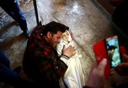 Salah Skaff, de 25 anos, chora sobre o corpo da sua filha, com um ano de idade, depois de um ataque aéreo dos rebeldes na cidade de Douma, na Síria.