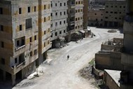 Abu Malek, um dos sobreviventes de um ataque químico que ocorreu em 2013, usa muletas para caminhar ao longo de uma rua na cidade de Ghouta, na Síria.