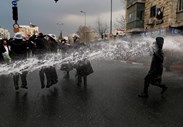 Manifestantes judeus ultra-ortodoxos são pulverizados com água pela polícia israelita, enquanto bloqueiam uma rua de Jerusalém durante uma manifestação contra a obrigação de membros da sua comunidade terem de entrar no exército.
