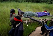 Os rebeldes do SPLA-IO carregam um ferido após um assalto aos soldados do governo SPLA (Exército Popular de Libertação do Sudão), na estrada entre Kaya e Yondu, Sudão do Sul.