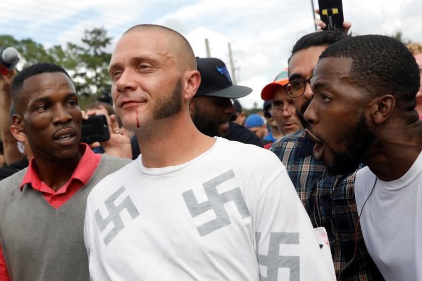 Um homem com sangue nos lábios é insultado durante um comício do movimento de extrema-direita “alt-right”, na Universidade da Florida, em Gainesville.