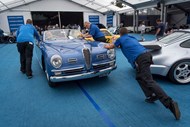Empregados empurram um Alfa Romeo 6C 2500 Super Sport Cabriolet de 1949 para a zona de leilões da Gooding & Co.