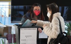 Eleitora coloca o seu voto dentro de um envelope selado no interior da urna.