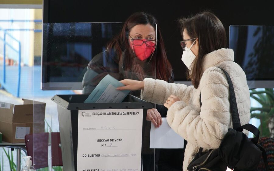 Eleitora coloca o seu voto dentro de um envelope selado no interior da urna.