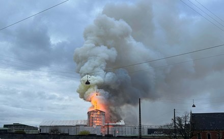 Antigo edifício da bolsa de Copenhaga em chamas. Pináculo colapsou