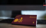Passaporte português em cima de uma secretária com computador