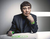 Retrato de Tadao Ando a desenhar num papel com uma caneta verde