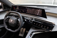 Interior do Peugeot E-3008 com painel digital, volante e sistema de navegação.
