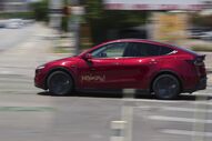 Carro vermelho com a inscrição 'RebaTaxi' em movimento