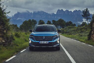 Um carro Renault azul viaja por uma estrada montanhosa