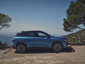 Um carro azul perto do mar num dia ensolarado
