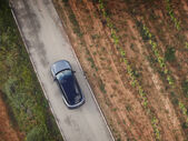 Vista aérea de carro numa estrada rural perto de um campo