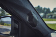 Detalhe do interior de um carro com foco no pilar e retrovisor