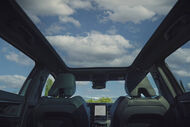 Interior de um carro com teto panorâmico e sistema de navegação