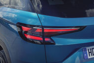 Detalhe da lanterna traseira de um carro azul com matrícula francesa