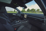 Interior de carro com estofos escuros e ecrã central