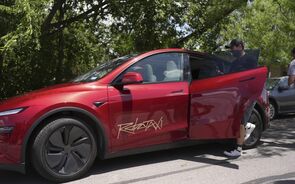 Tesla Robotaxi com passageiro a entrar no carro.