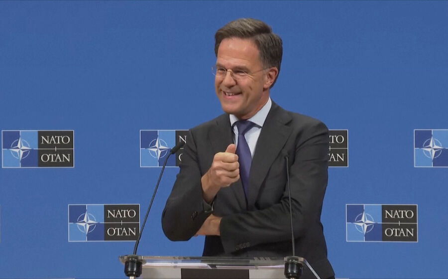 Mark Rutte discursa com o logótipo da NATO no fundo