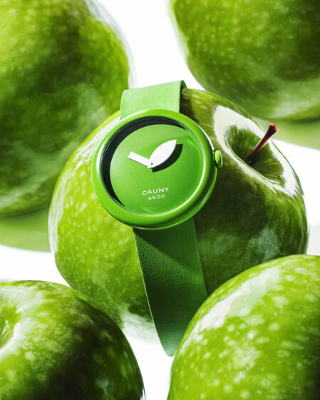Relógio Cauny Ando verde entre maçãs para indicar o tempo de vida