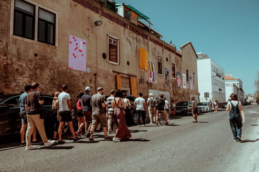 Grupo de pessoas visita obras de arte expostas num edifício em Lisboa