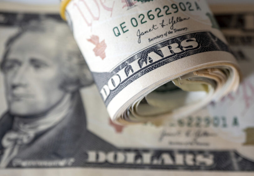 Notas de dólar americanas enroladas e presas com um elástico