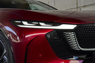 Detalhe da frente de um carro vermelho com faróis LED brancos
