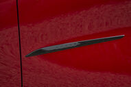 Emblema da marca Mazda num carro vermelho