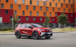 Um carro vermelho da Renault em movimento numa estrada