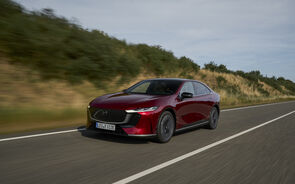 Carro vermelho da Mazda a conduzir numa estrada