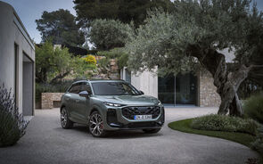Um SUV verde estacionado perto de uma casa moderna