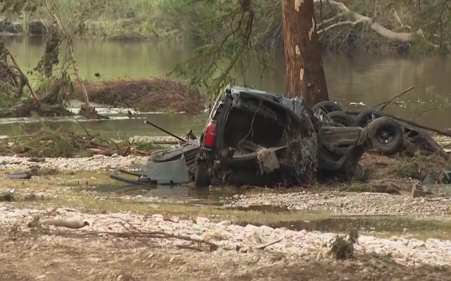 Carro destruído perto de um rio após inundações
