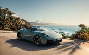 Um Porsche 911 Carrera descapotável numa estrada costeira
