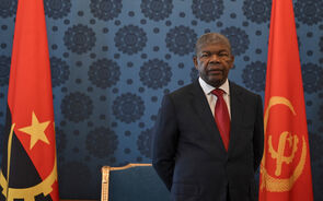 João Lourenço, Presidente de Angola, posa entre as bandeiras do país