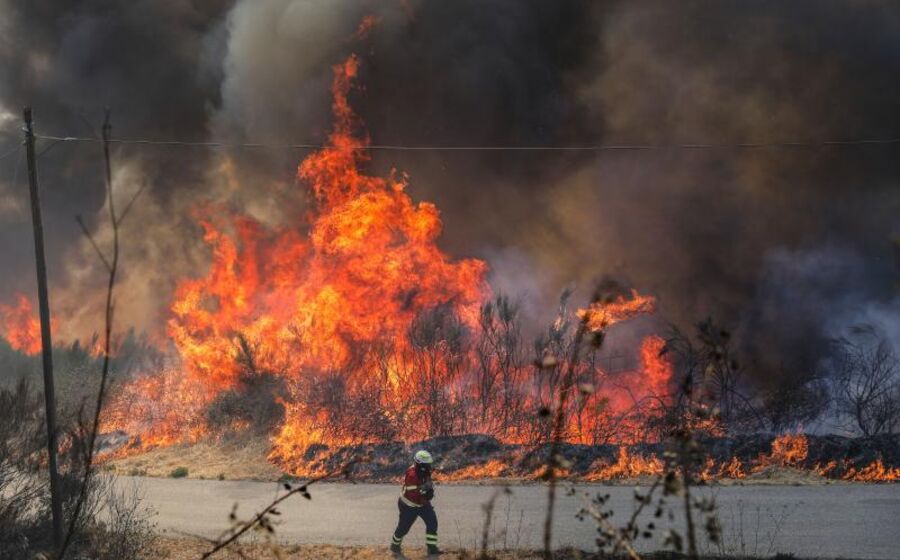 Um bombeiro combate as chamas durante o incêndio na encosta da aldeia de Moura da Serra, Arganil.