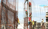 Trabalhadores da construção civil em obra com armaduras de aço